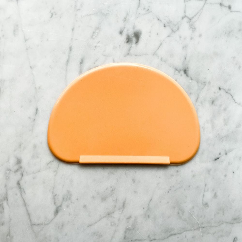 orange sourdough bowl scraper on marble