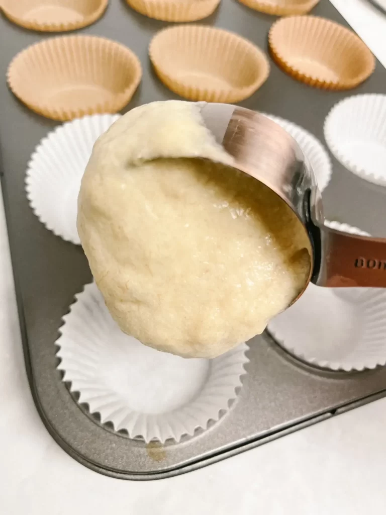 banana muffin batter being added to a muffin tin