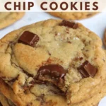 sourdough chocolate chip cookies stacked on top of each other. The top cookie has a bite taken out of it.