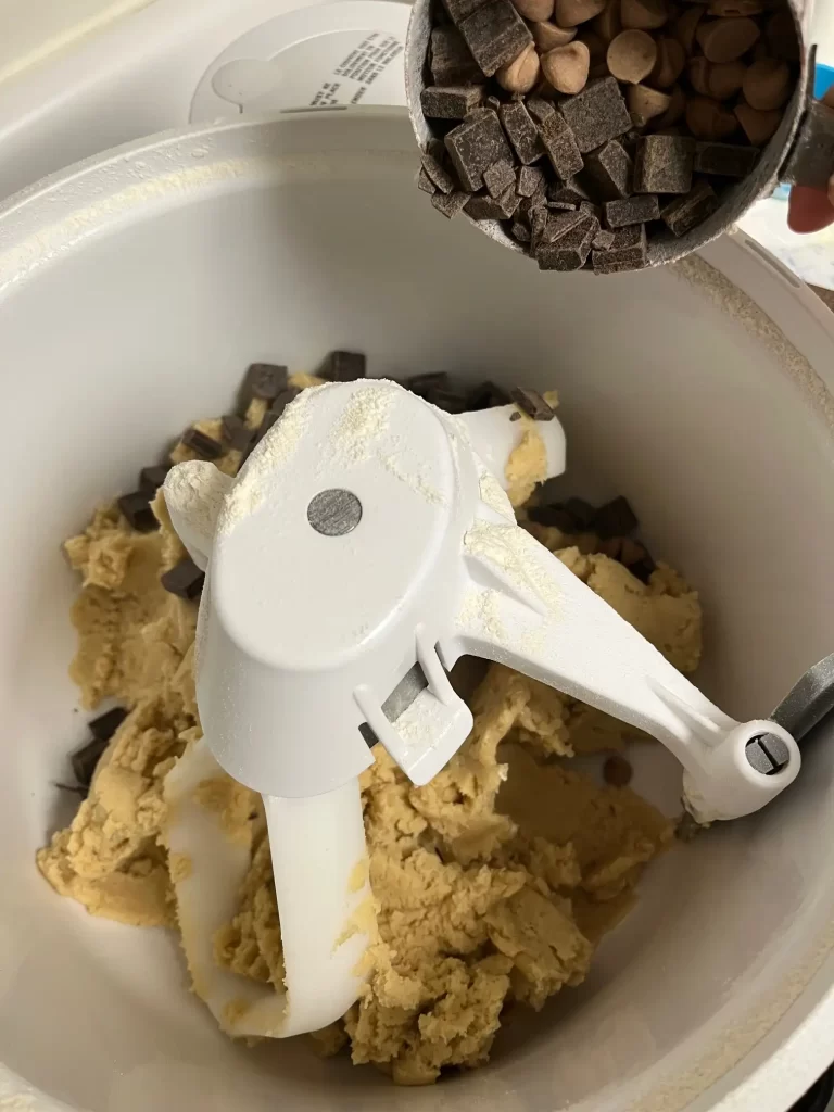chocolate chip cookies and sea salt caramel chips pouring into a bosch mixer