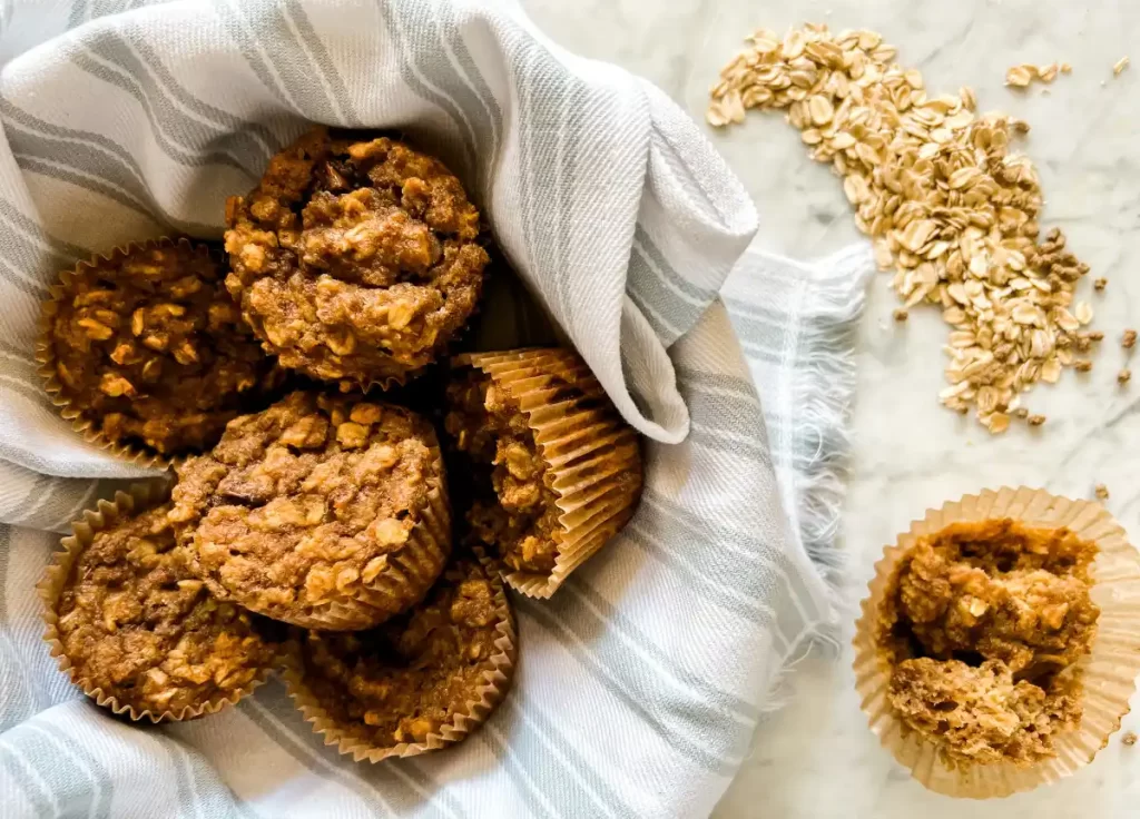 sourdough bran muffins in a basket with oatmeal on the side