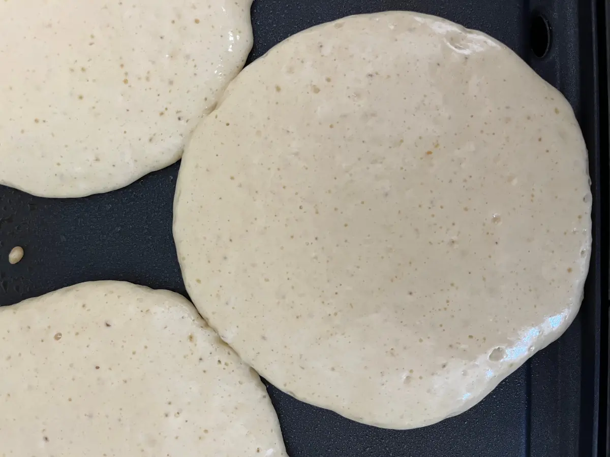 sourdough pancakes ready to flip on a griddle