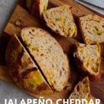Jalapeño Cheddar Sourdough Bread sliced on a wooden cutting board.
