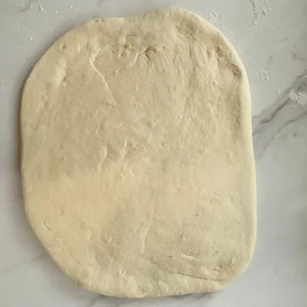 sourdough cinnamon roll dough rolled out into a rectangle.