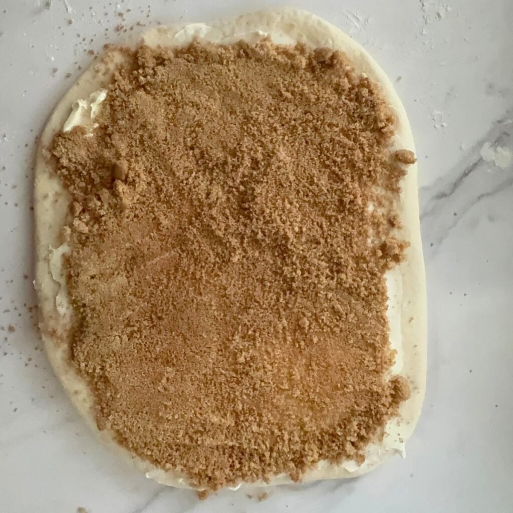 Butter, sugar, and cinnamon added to cinnamon roll dough.