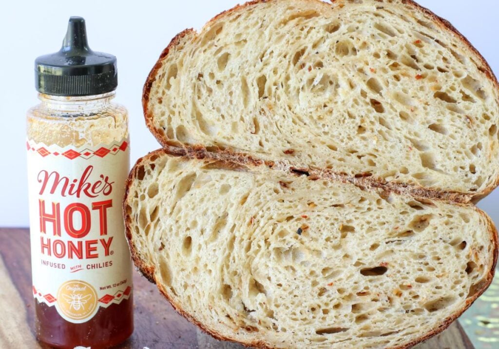 2 halves of sourdough bread next to a bottle of mike's hot honey