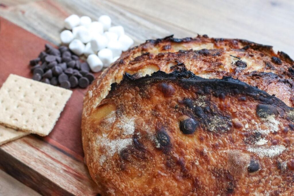 graham crackers, chocolate chips and marshmallows next to a smores sourdough bread