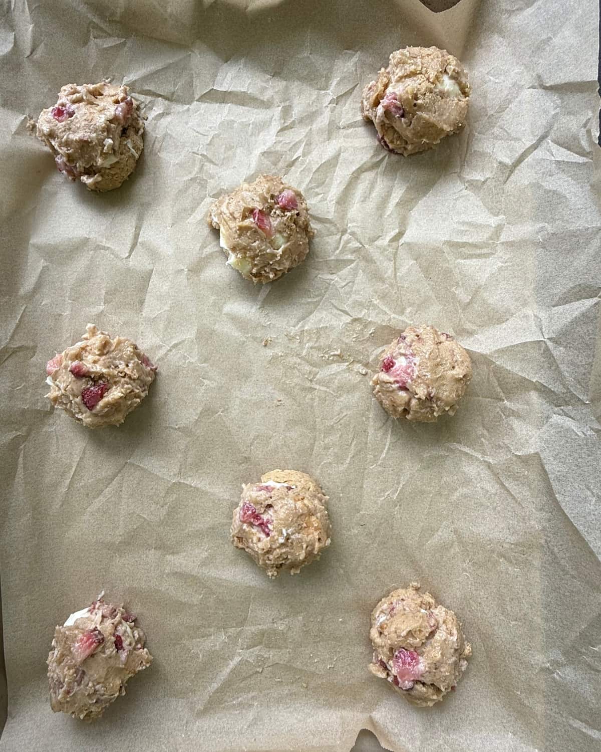 8 sourdough strawberry cheesecake cookies on a piece of parchment paper before baking.