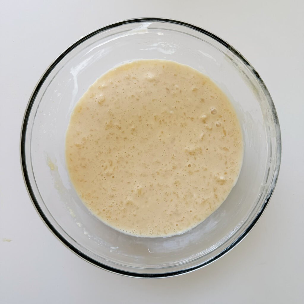 Wet ingredients for sourdough mini muffins in a clear bowl.