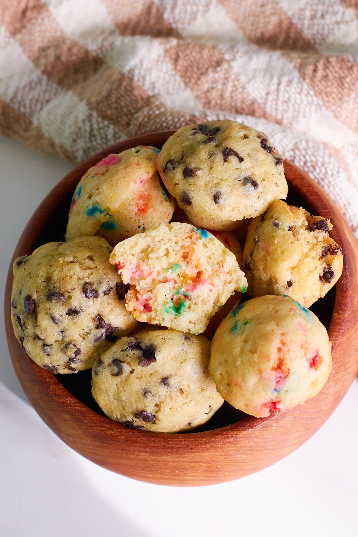 Wooden bowl holding sourdough mini muffins.