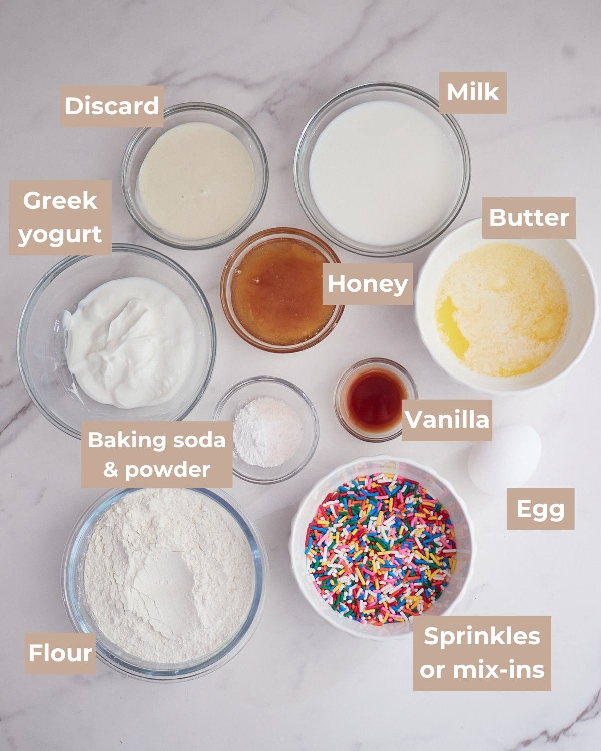 Ingredients for sourdough mini muffins on a white background in clear bowls.