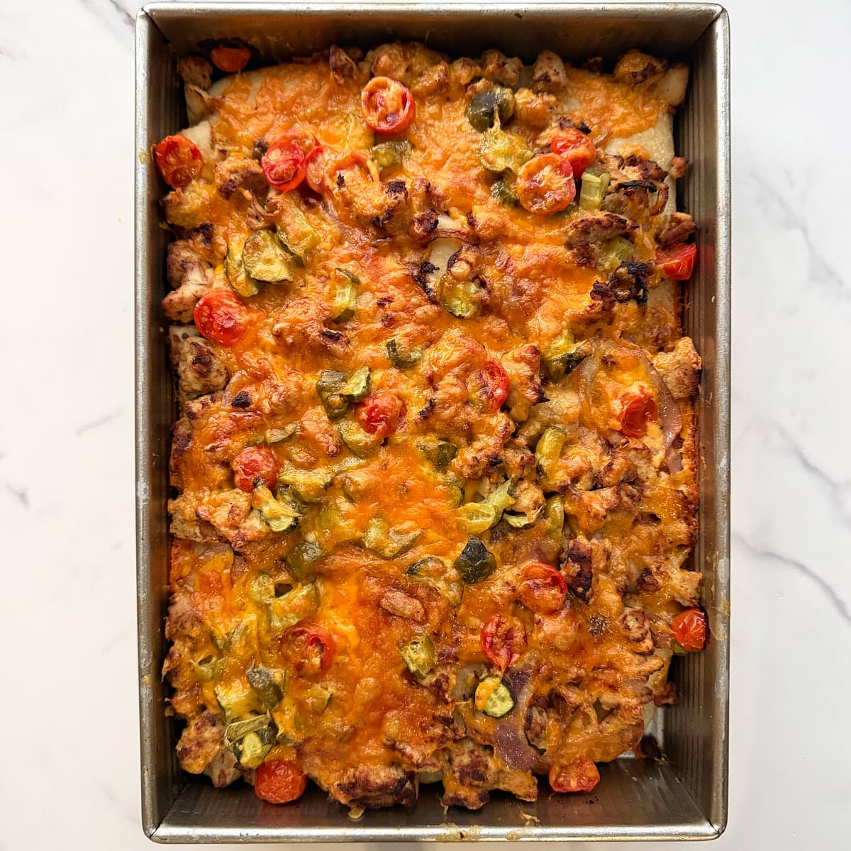Baked focaccia in a 9x13 pan with Cheeseburger toppings.