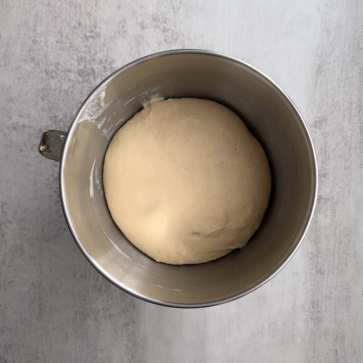Sourdough pizza dough doubled in size in a pan.