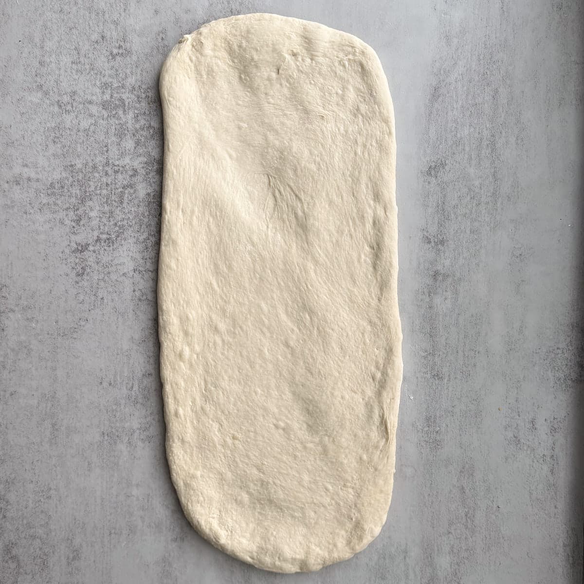 Sourdough pizza wreath dough rolled in to a long rectangle.