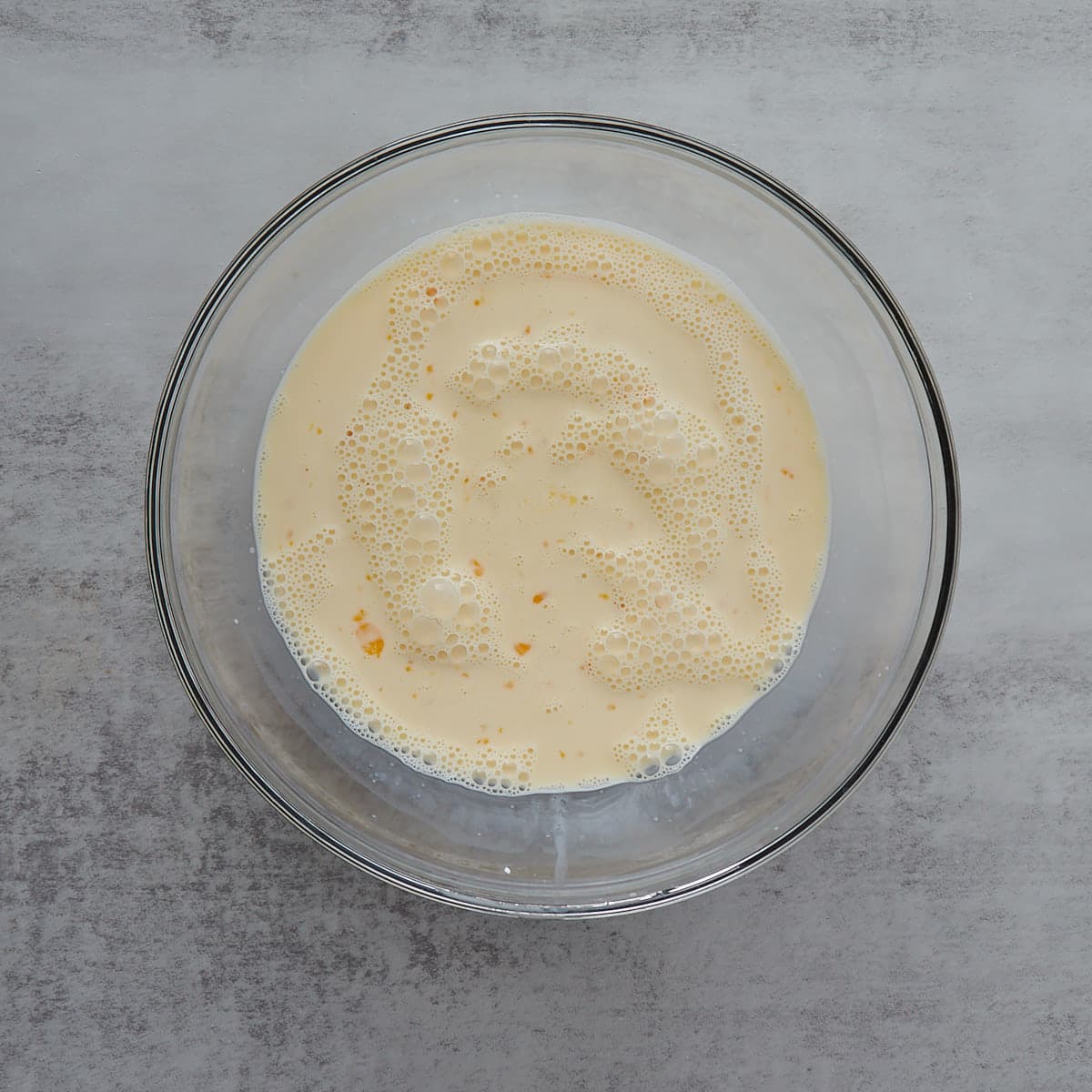 Milk, egg, sourdough discard in a glass bowl all mixed together. 