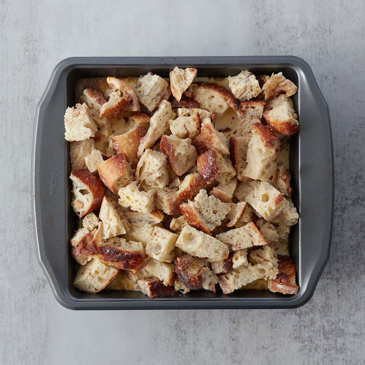 Bread cubed on top of the caramel mixture in a 9x9 inch pan. 