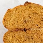 Sourdough pumpkin bread sliced in half and stacked on top of each other.