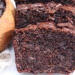 Slices of Chocolate Sourdough Banana Bread next to a small wooden bowl of chocolate chips.