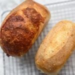 Overhead view of sourdough mini bread loaves on a wire rack.