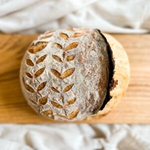 freshly baked artisan sourdough bread with leaves scored on top