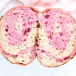 Pink Swirl Sourdough Bread cut in half next to a pink and white napkin.