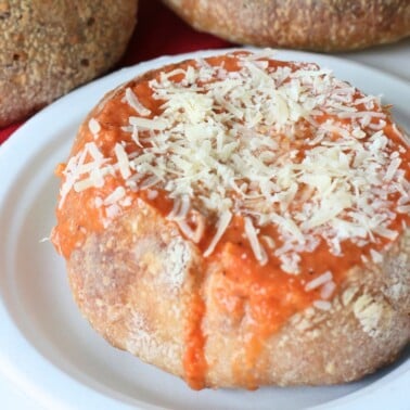 Sourdough bread bowl filled with tomato soup with cheese on top.