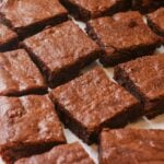 Sourdough brownie cut into squares on top of parchment paper.