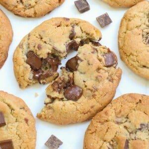 Sourdough Chocolate Chip Cookie cut in half with gooey chocolate on a white background.