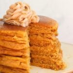 A stack of sourdough pumpkin pancakes with honey butter on top.