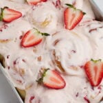 strawberry rolls in a pan with cut strawberries on top