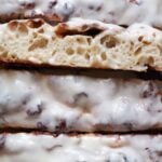 Close up on slices of Cinnamon Roll Sourdough Focaccia with cream cheese frosting