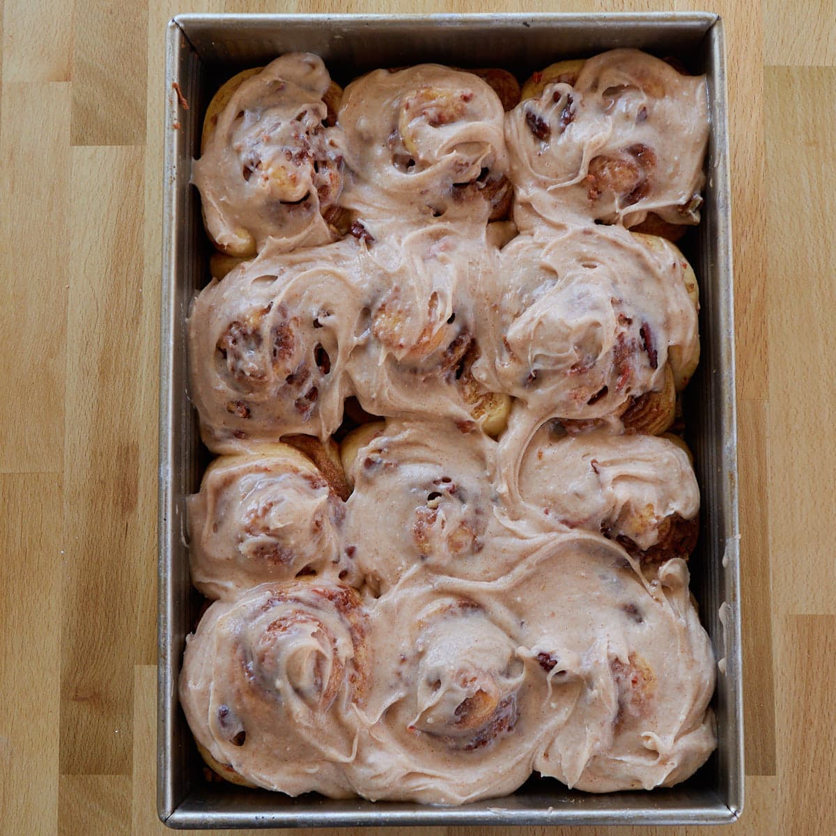 Brown butter cream cheese frosting on carrot cake sourdough cinnamon rolls. 