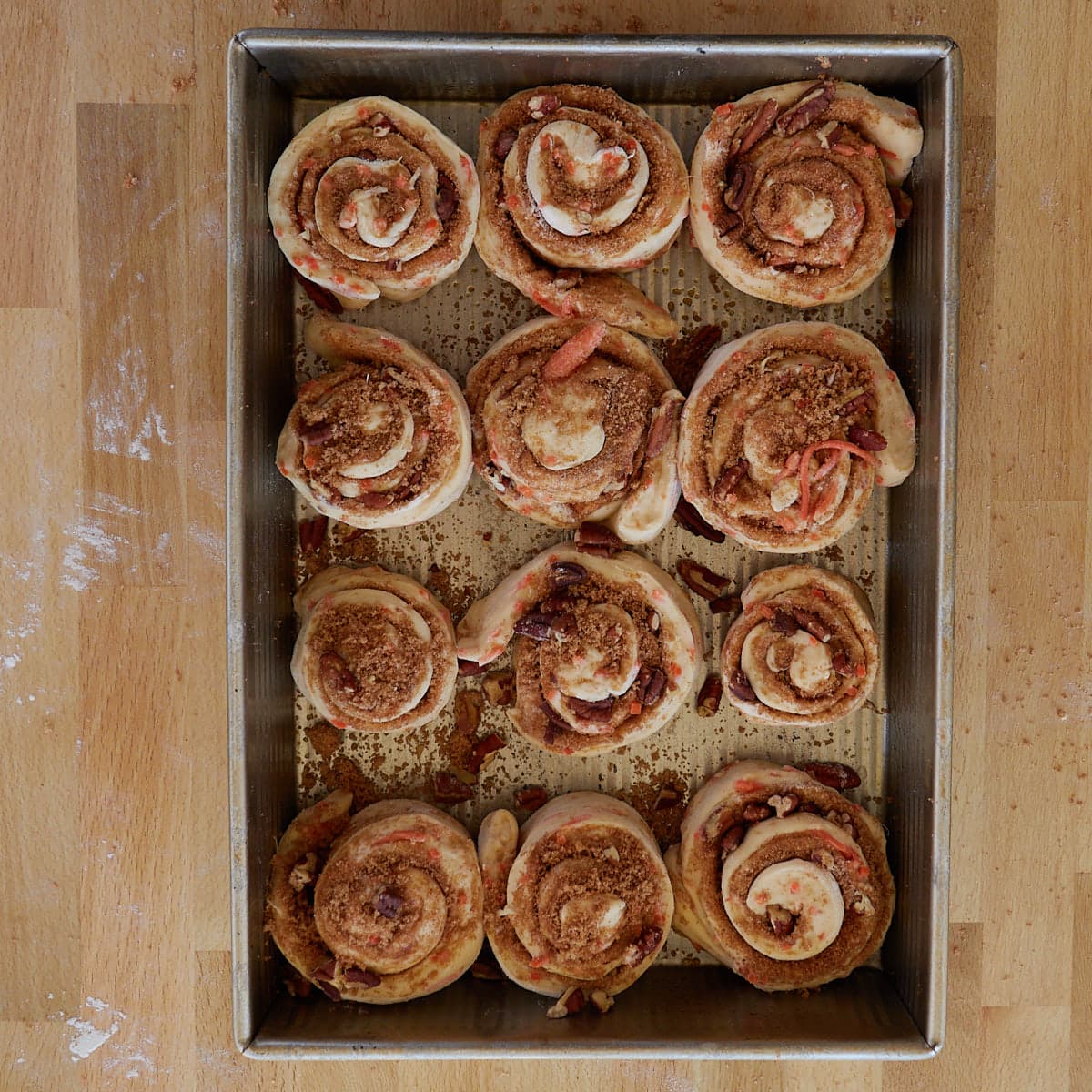 12 rolled up carrot cake sourdough cinnamon rolls in a greased 9x13 inch pan. 