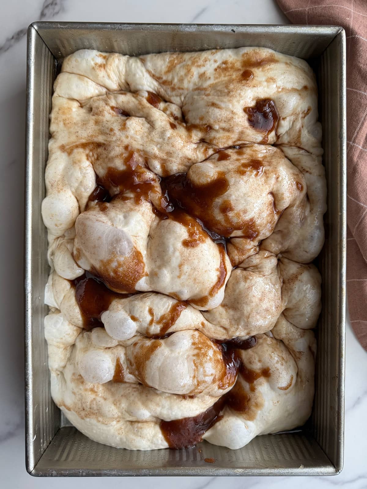 Dimpled sourdough cinnamon sugar dough with buttery cinnamon sugar on top.