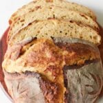 Loaf of Einkorn Sourdough Bread with three slices on top of a wooden board.