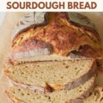 Loaf of Einkorn Sourdough Bread with three slices on top of brown parchment paper.