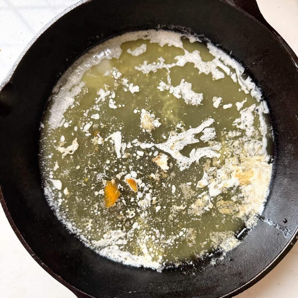 Butter melted in a cast iron pan.