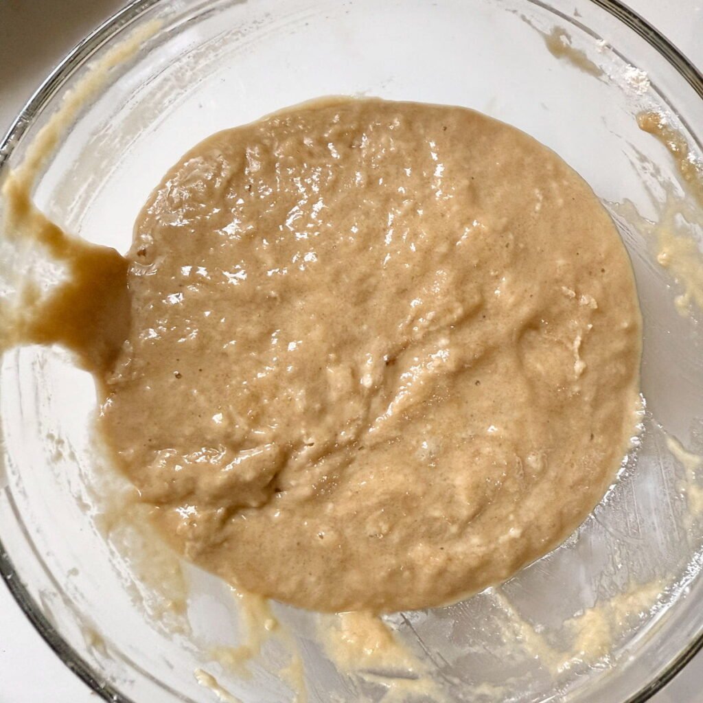 Batter for sourdough cobbler mixed in a clear bowl.