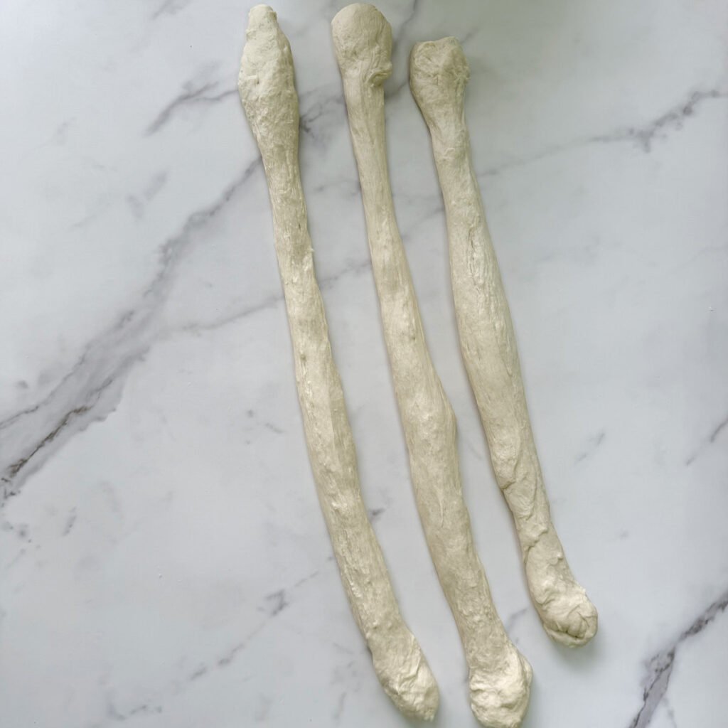 Sourdough Pretzel dough rolling into 3 long logs.