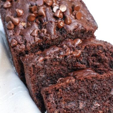 Chocolate sourdough banana bread sliced on top of a cream colored napkin.