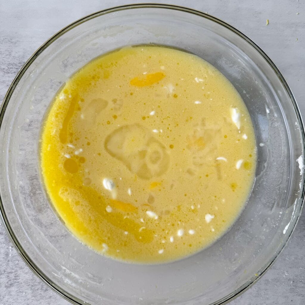 Wet ingredients for Lemon Poppyseed Sourdough Muffins in a clear bowl.