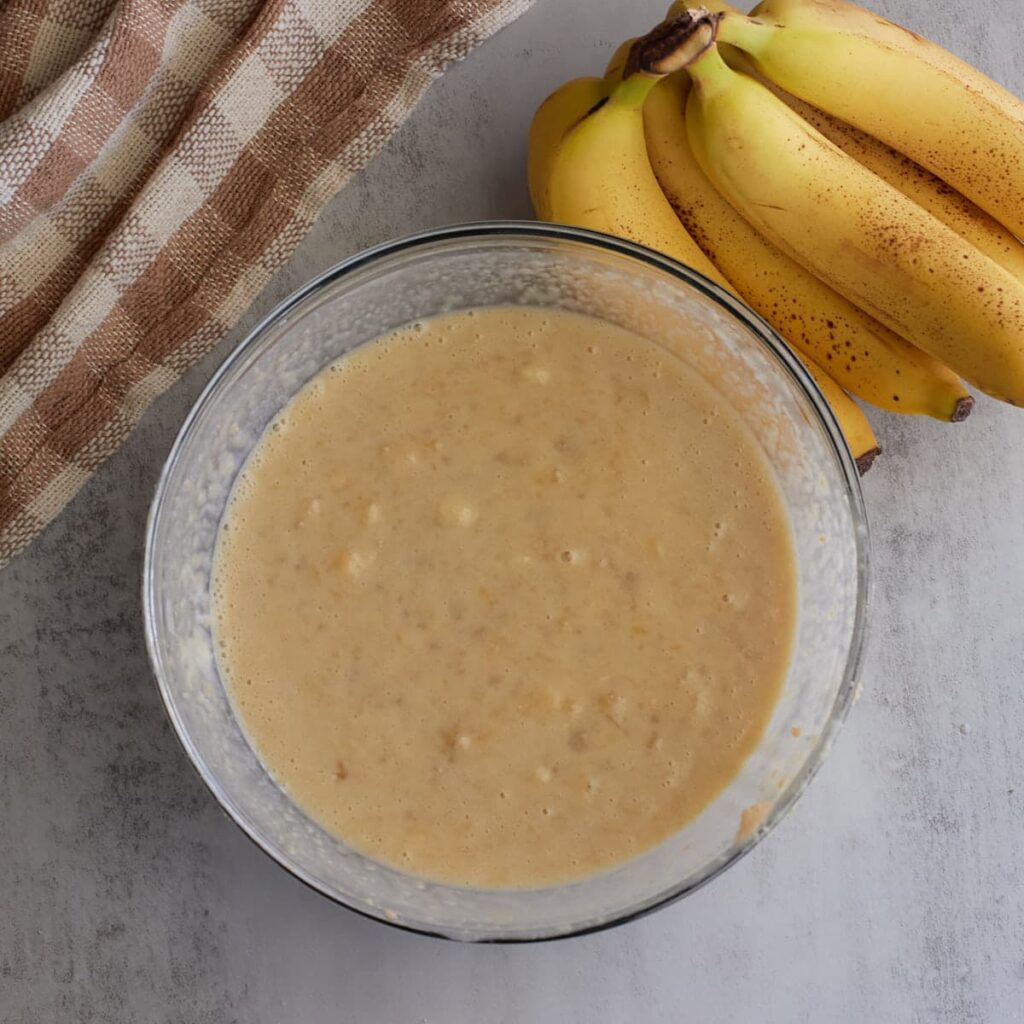Wet ingredients for sourdough banana muffins mixed in a clear bowl.
