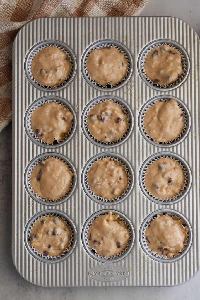 Batter for sourdough banana muffins added to a paper lined muffin tin.