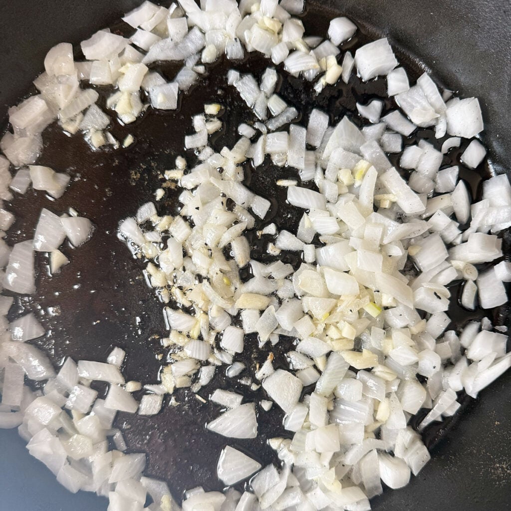 Diced onions saut&eacute;ed in a cast iron skillet for chicken pot pie.