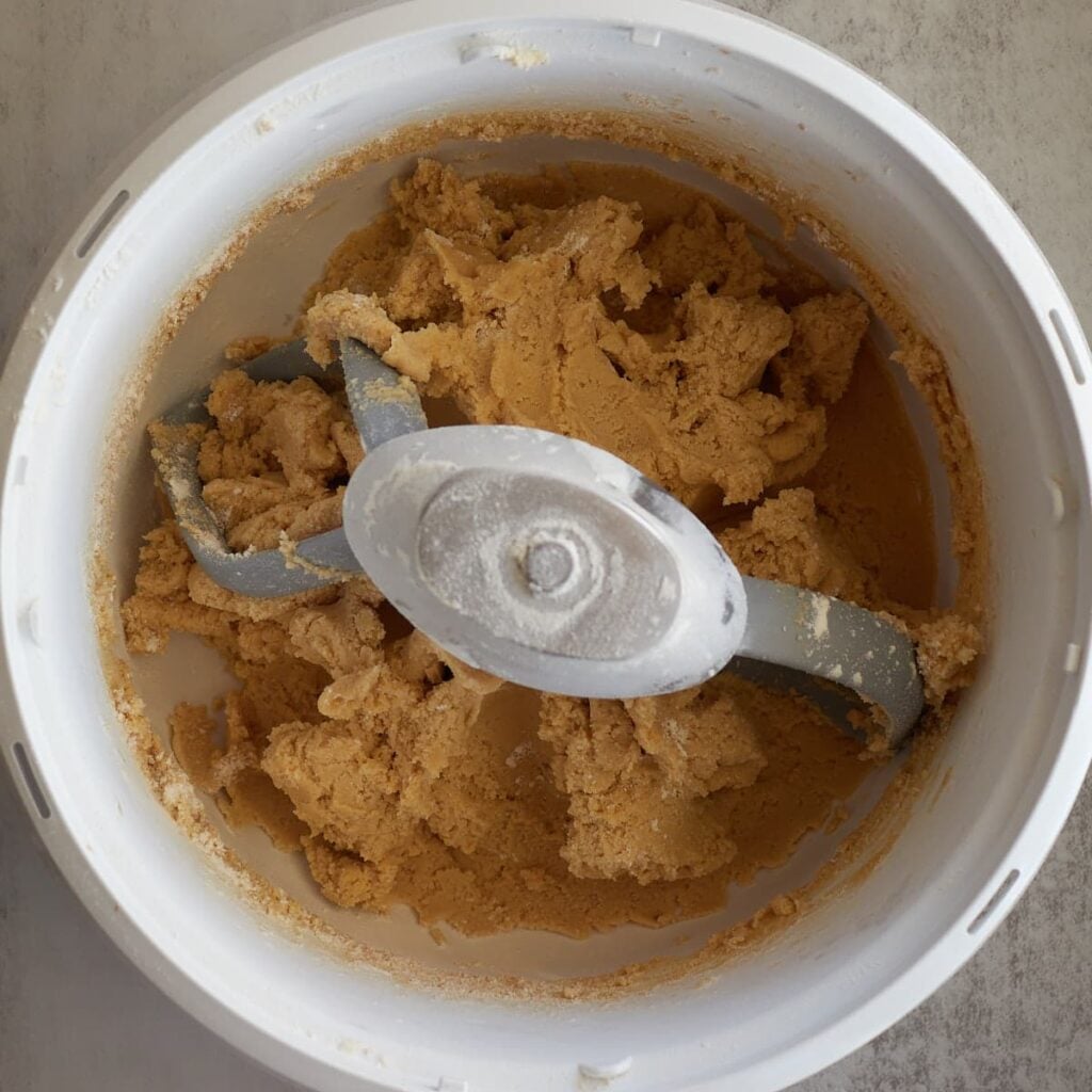 Dry ingredients added to sourdough chocolate chip cookie dough in a bosch mixer.