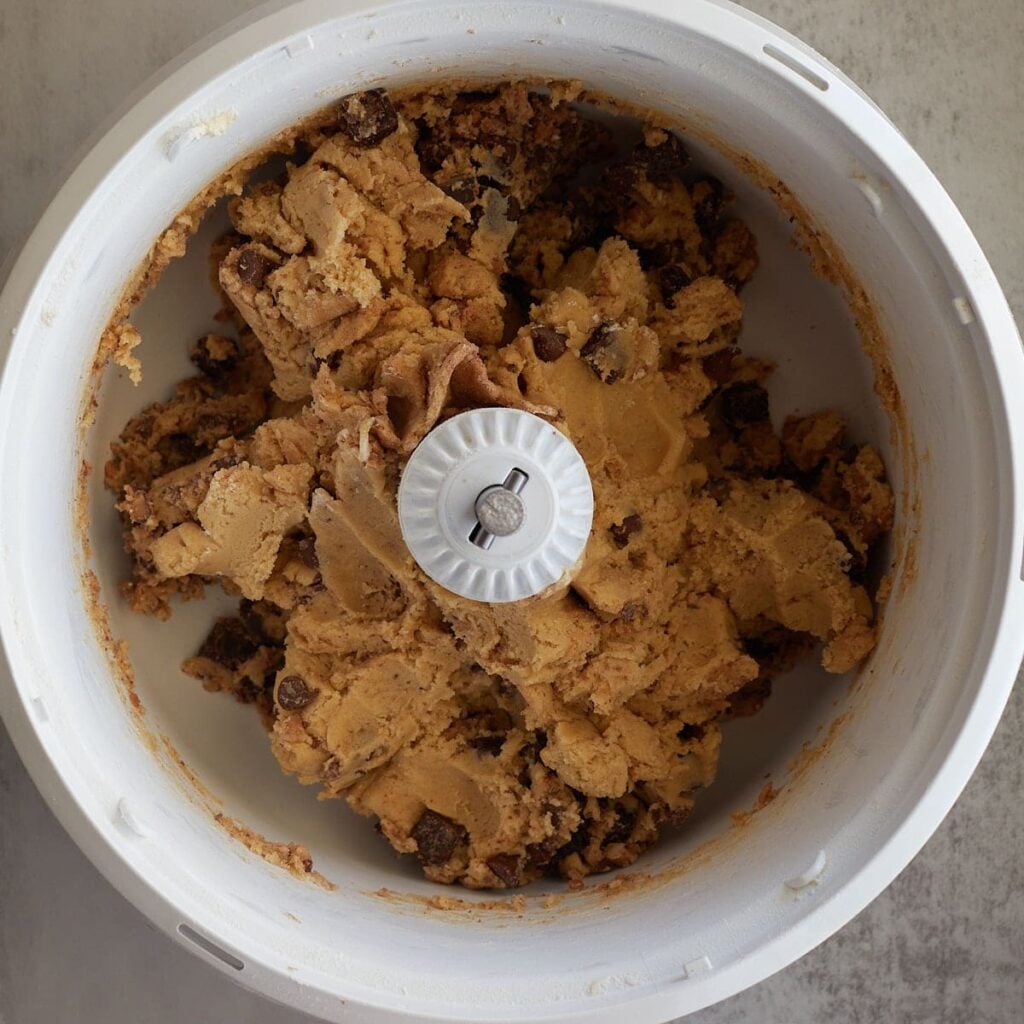 Chocolate chips and english toffee bits added to cookie dough in a bosch mixer.