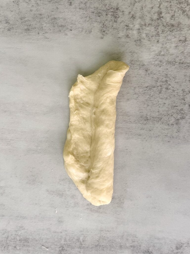 Rolling up sourdough hot dog bun dough.