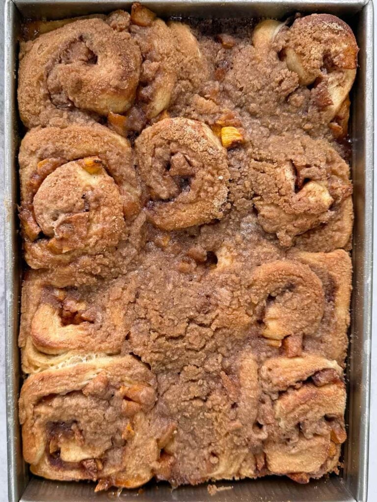 Freshly baked sourdough peach cobbler cinnamon rolls with crumb topping.