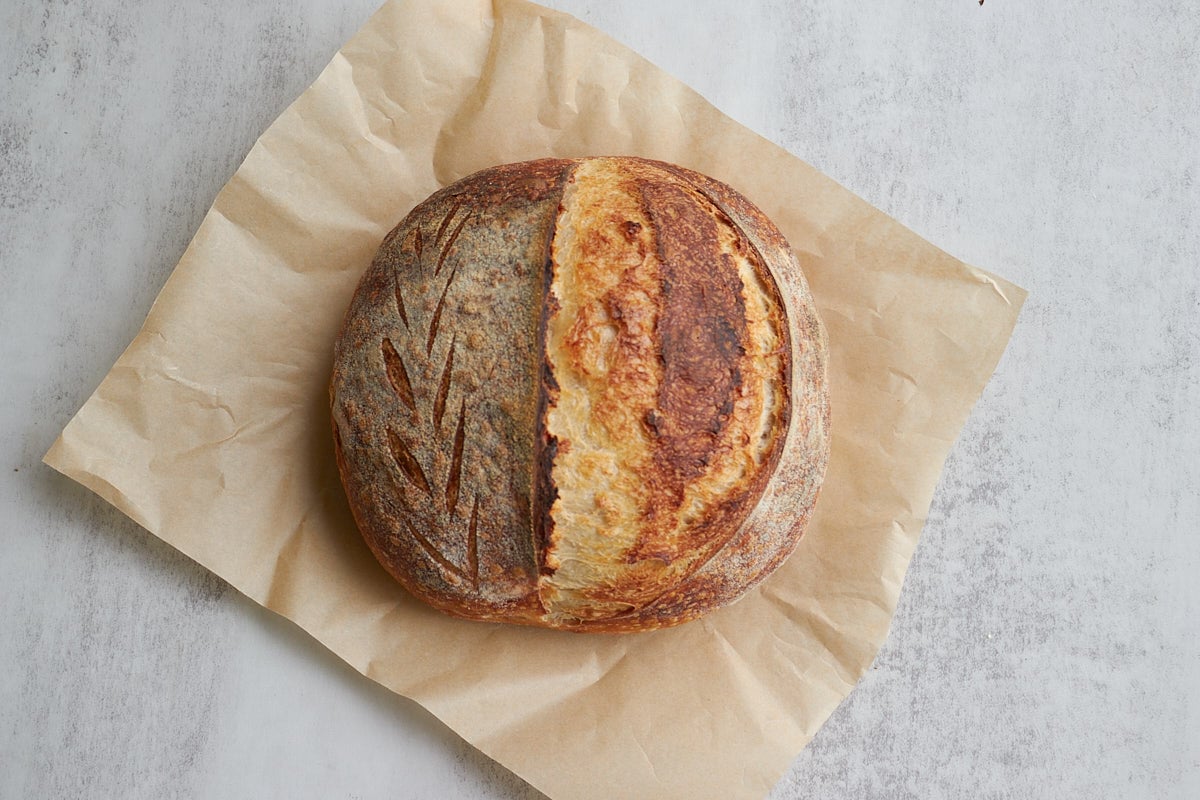 Same day sourdough bread on a piece of brown parchment paper.