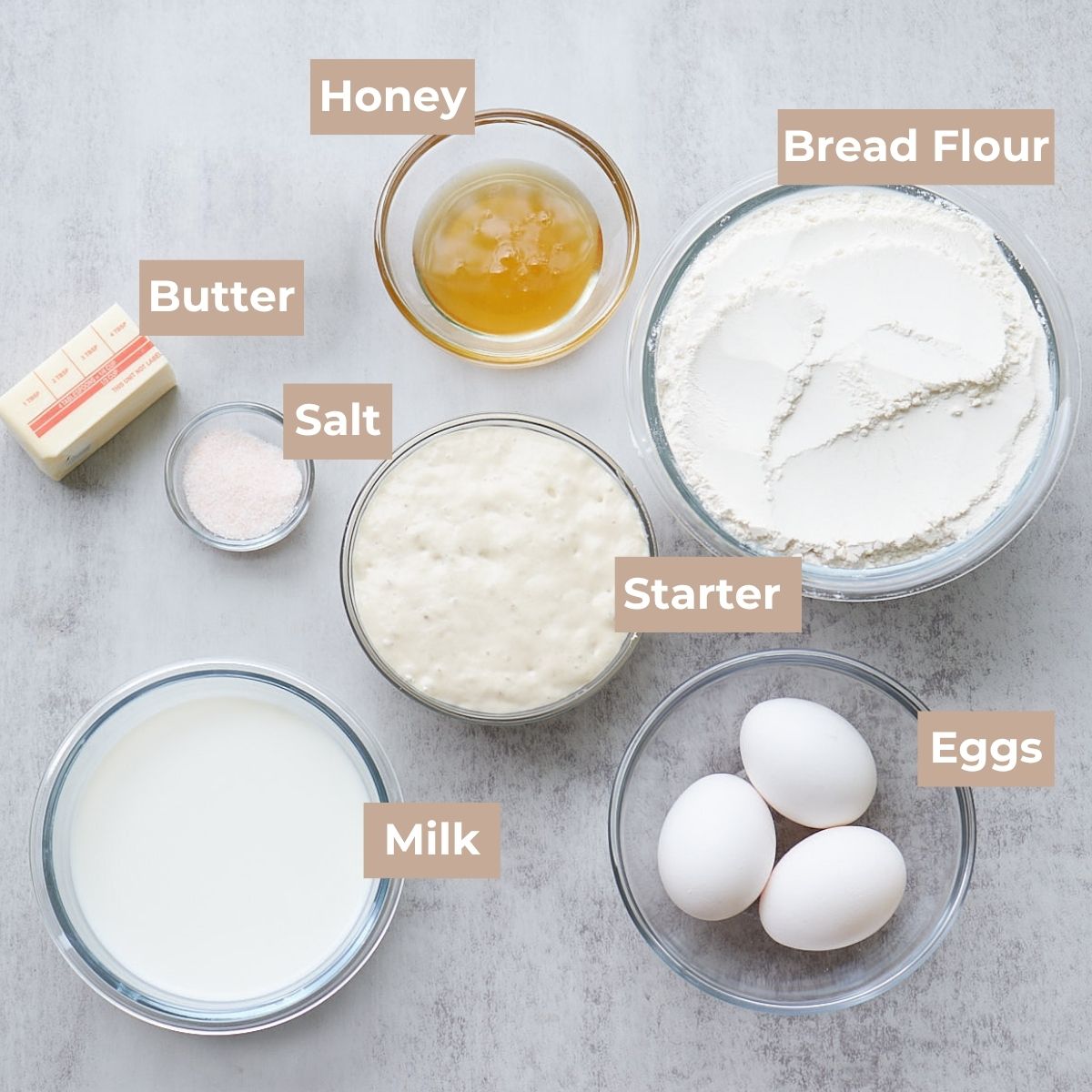 Ingredients for Sourdough Hot Dog Buns in clear bowls.